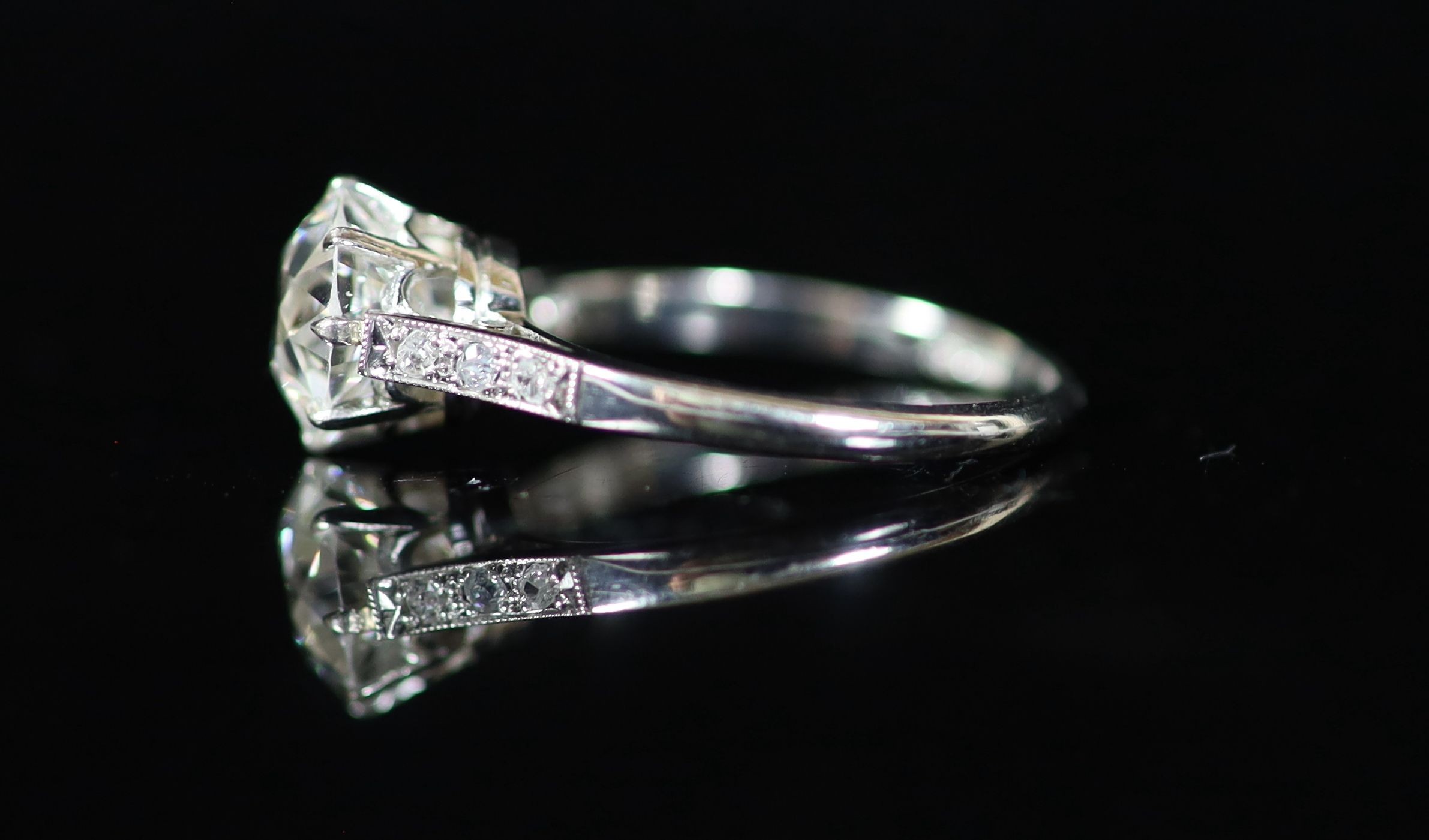 A platinum and single stone diamond ring, with diamond set shoulders